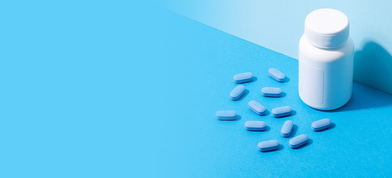 Tablettenbox und blaue Tabletten auf blauem Boden